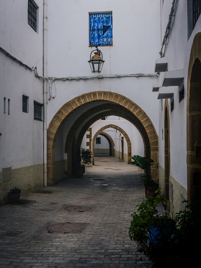 Quiet alley with stone arches in Rabat's historic Medina. Perfect for travel enthusiasts and architecture lovers.